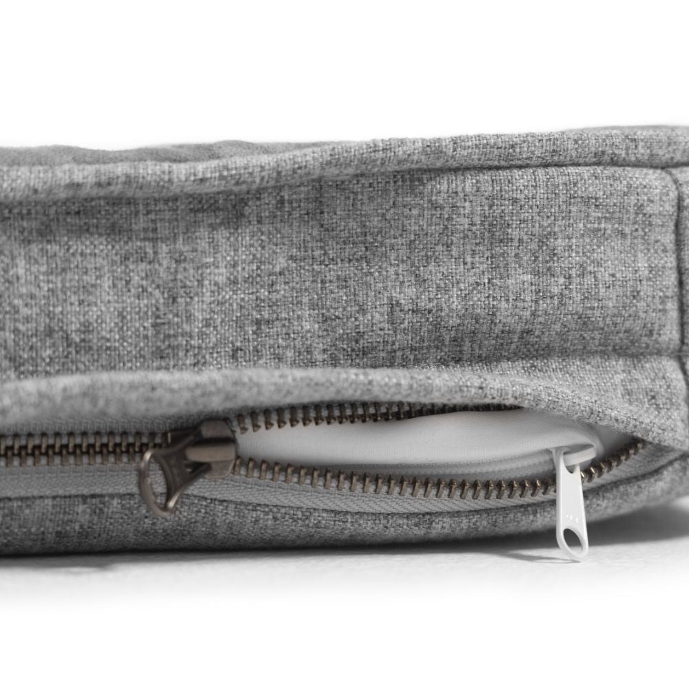a close up of a grey snooz pad with the outer cover partially unzipped