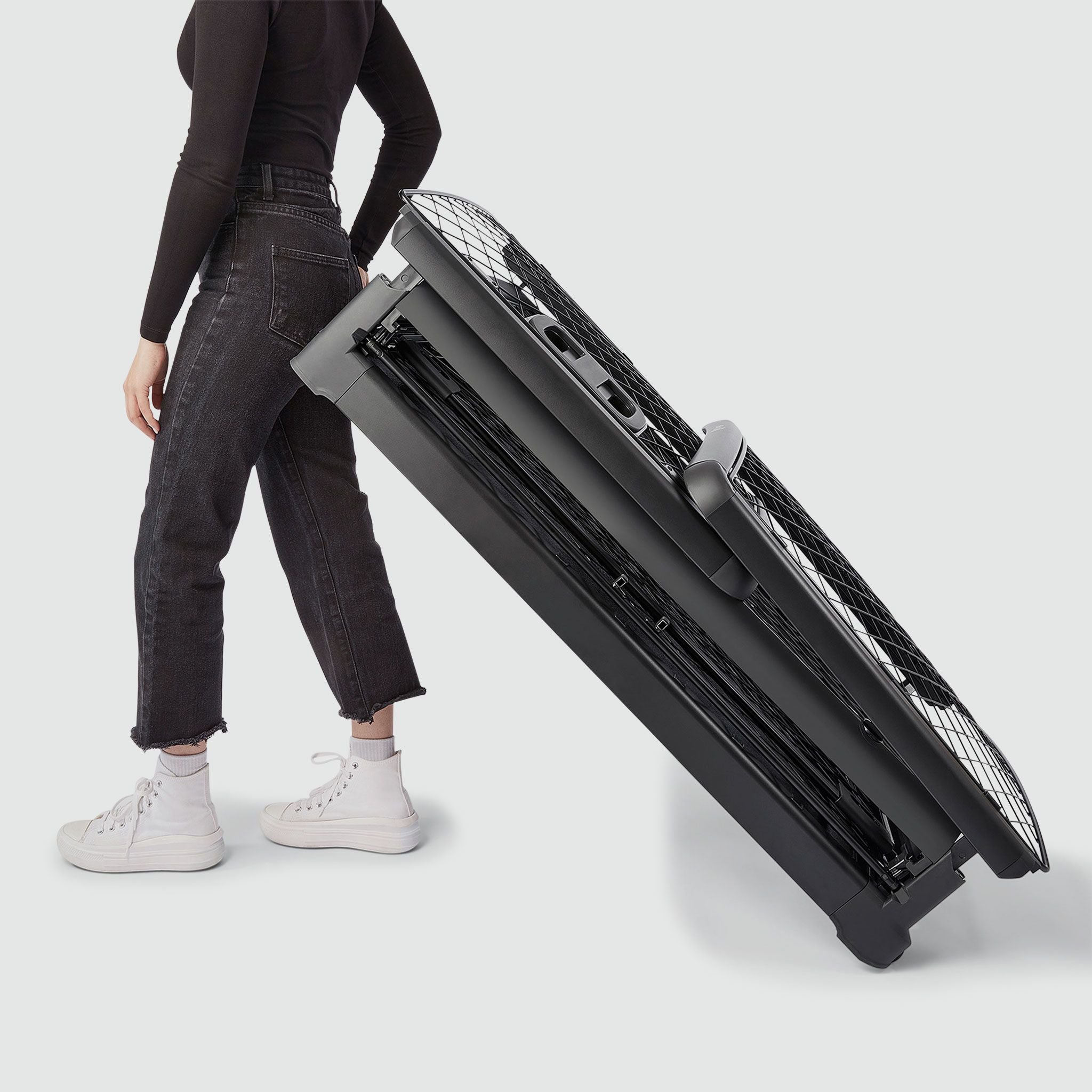 A woman wheeling a folded Revol crate