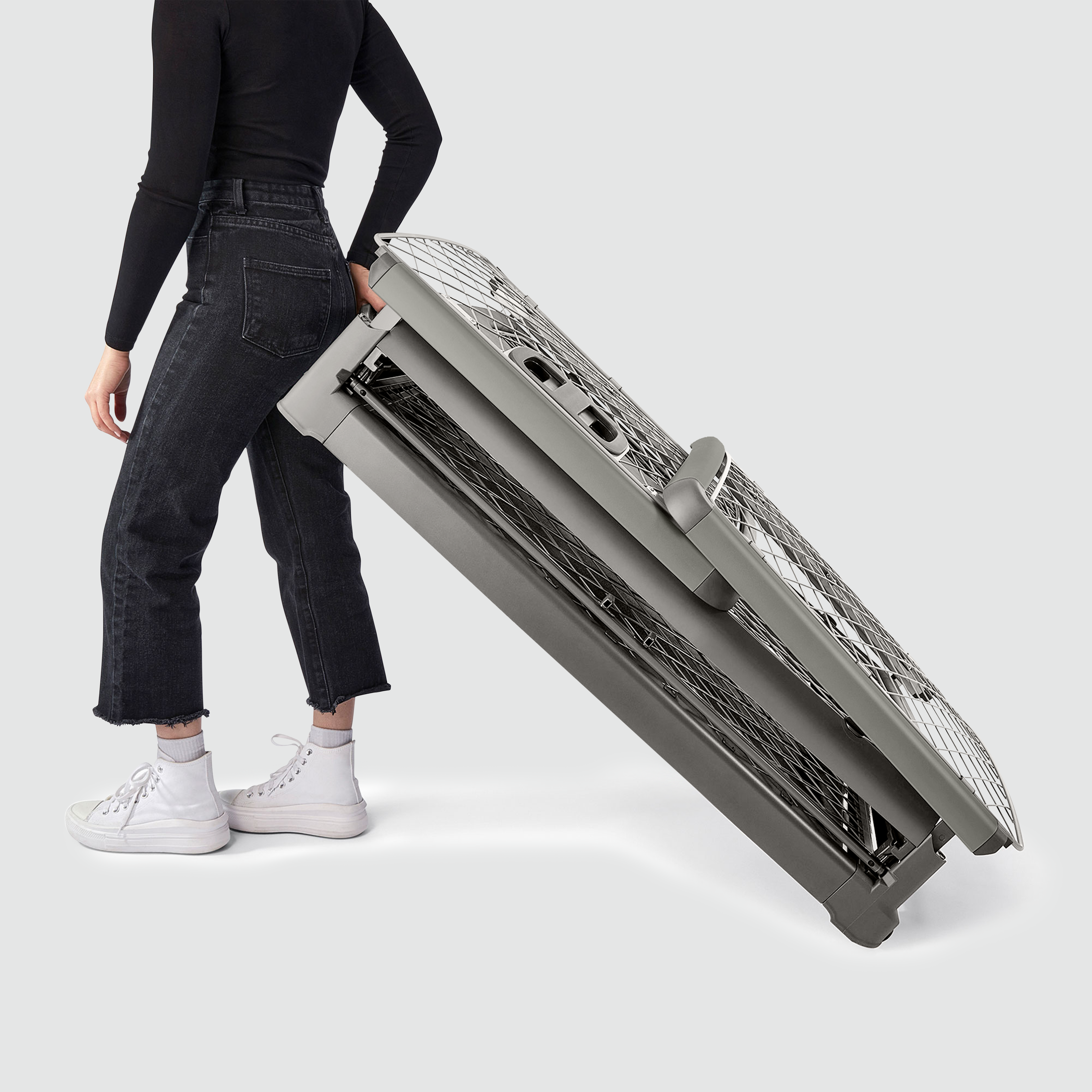 A woman wheeling a folded Revol crate