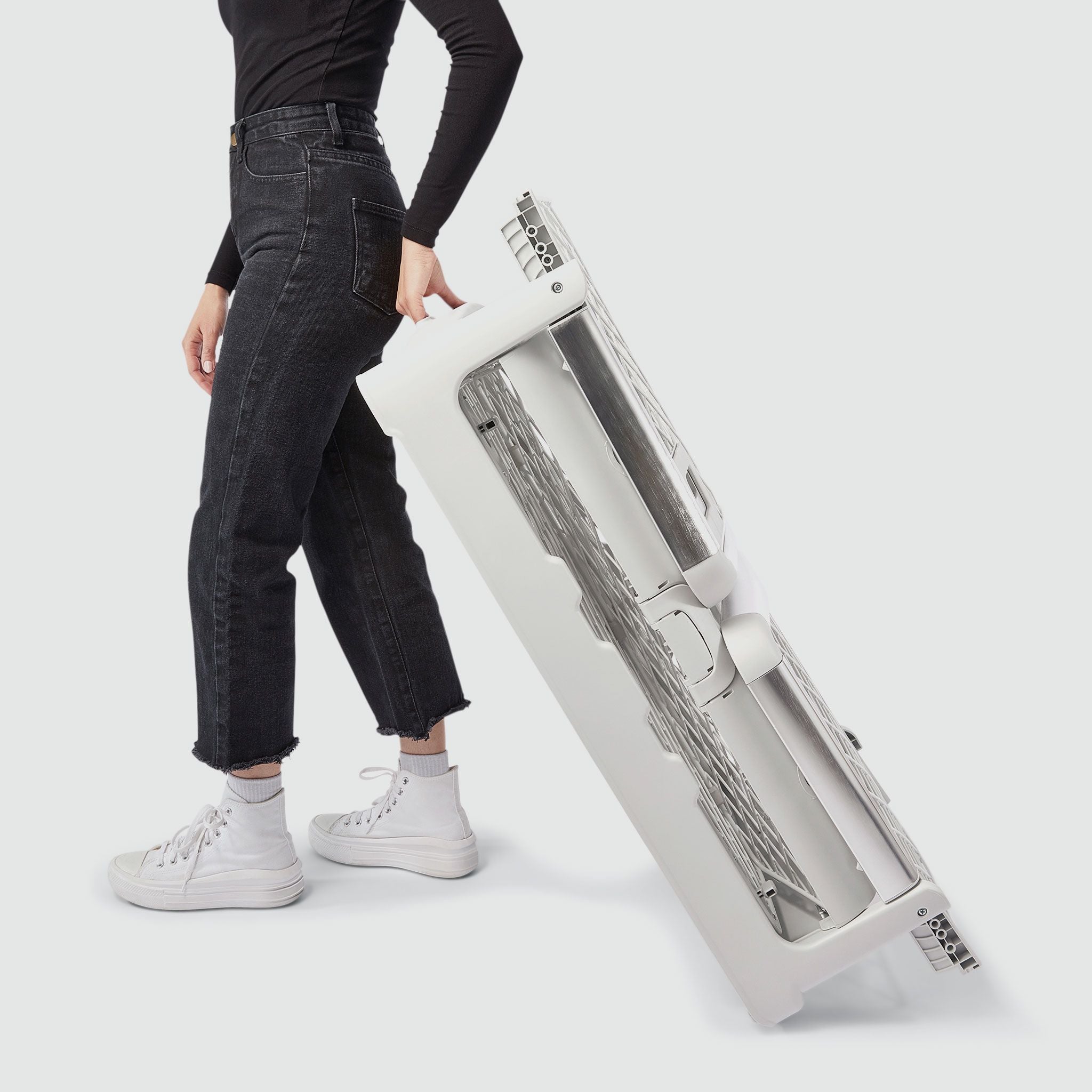 A woman wheeling a folded Revol crate
