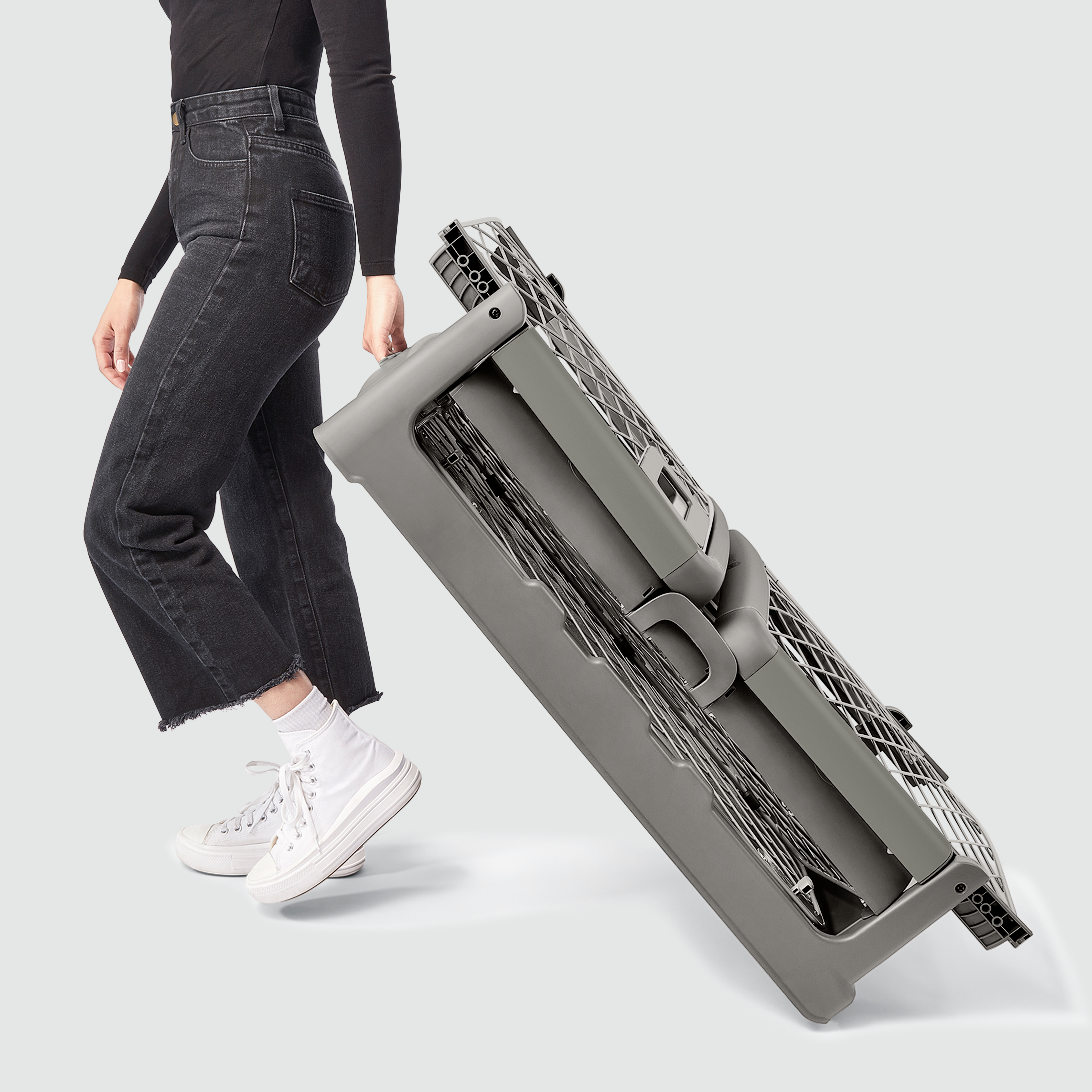 A woman wheeling a folded Revol crate