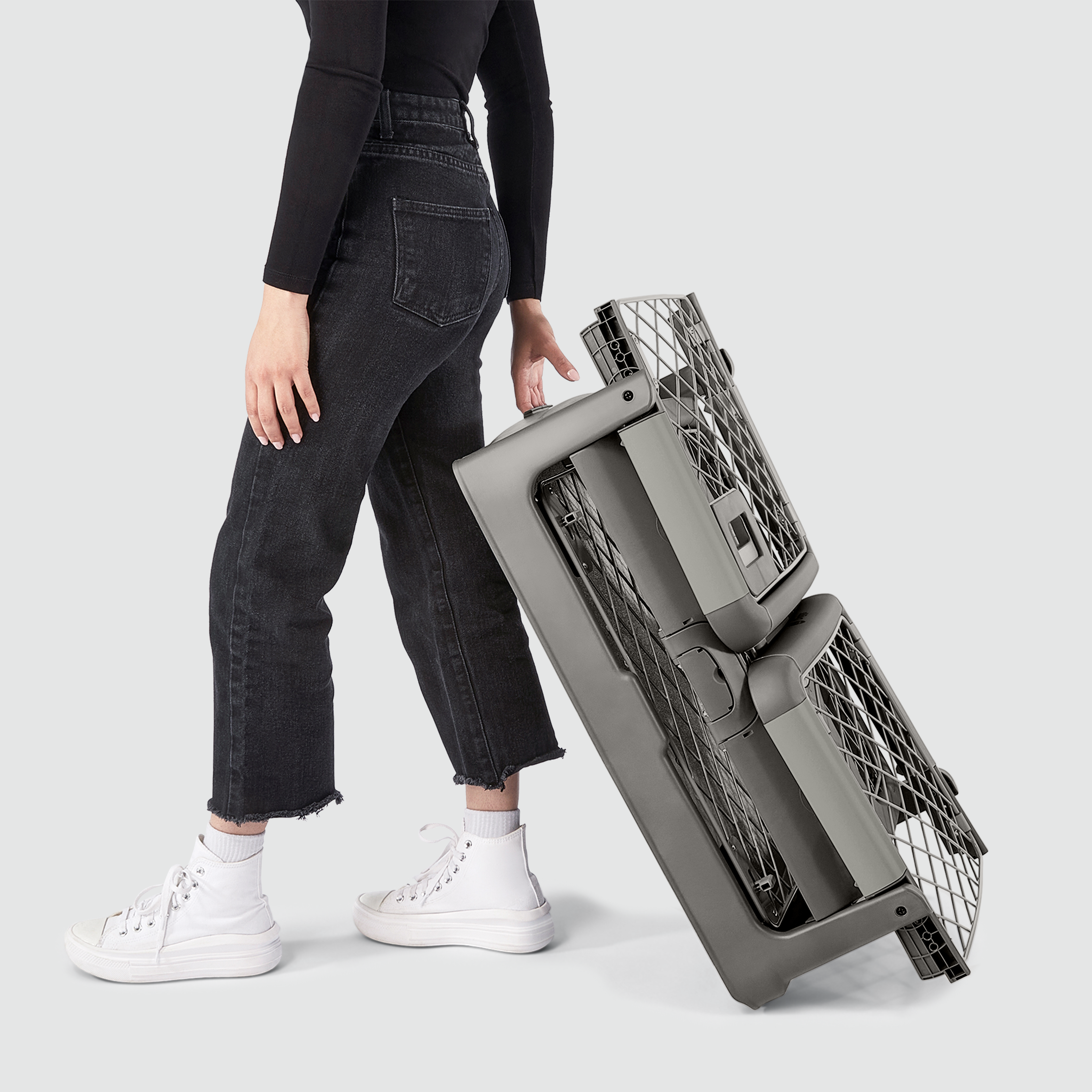 A woman wheeling a folded Revol crate