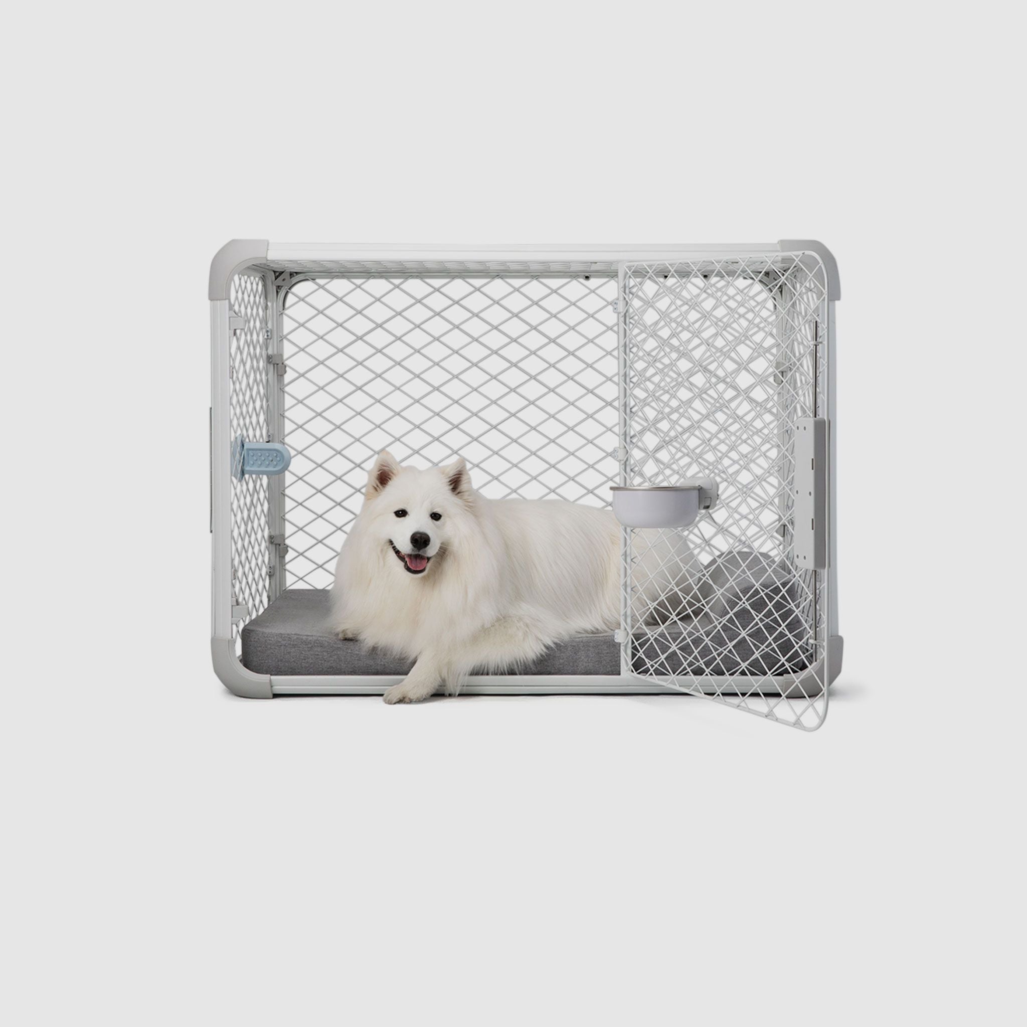 Side view of a dog laying on a Bolstr bed inside of an Evolv Dog Crate with open side door.