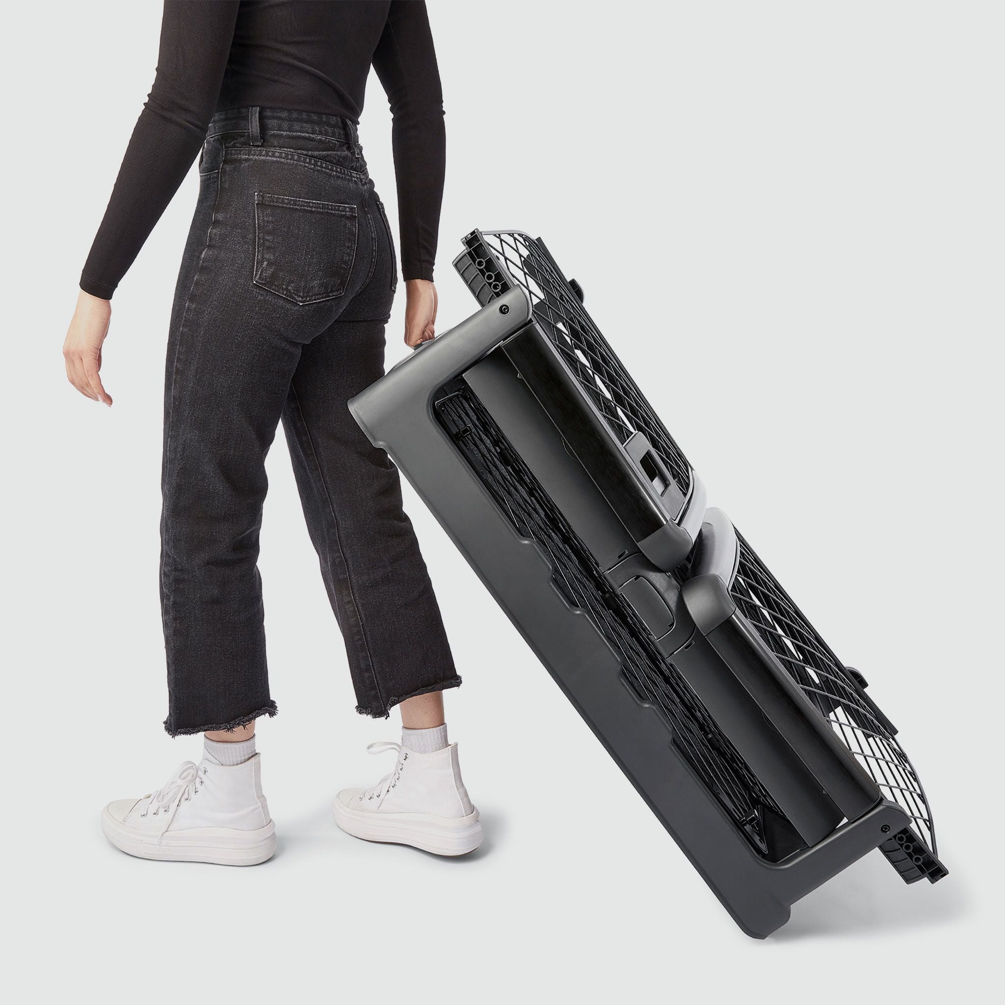 A woman wheeling a folded Revol crate