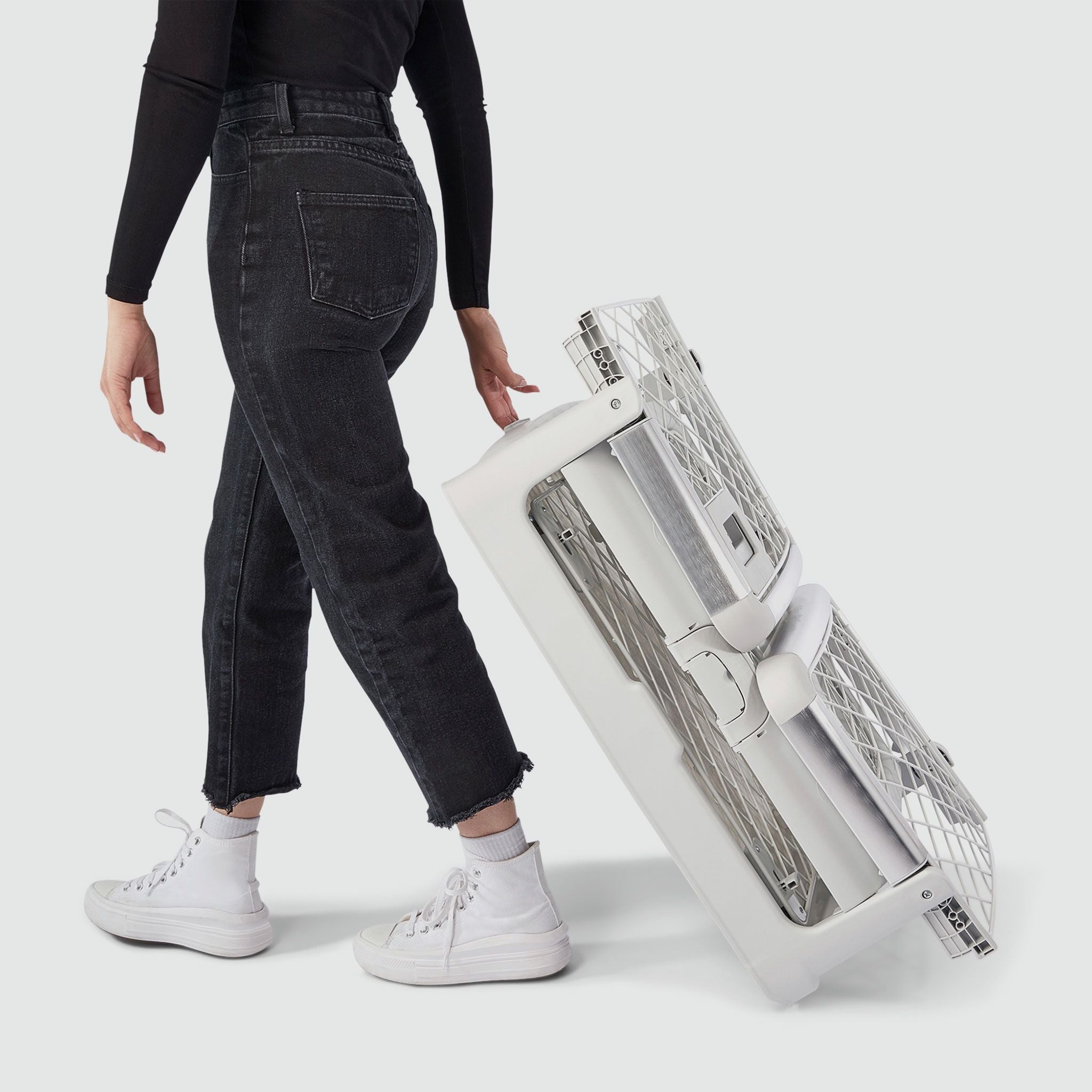 A woman wheeling a folded Revol crate