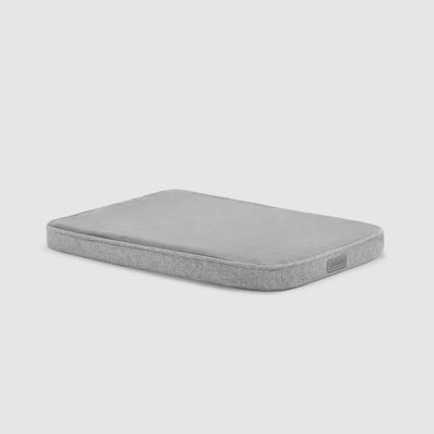 A gray mattress with no sheets on it