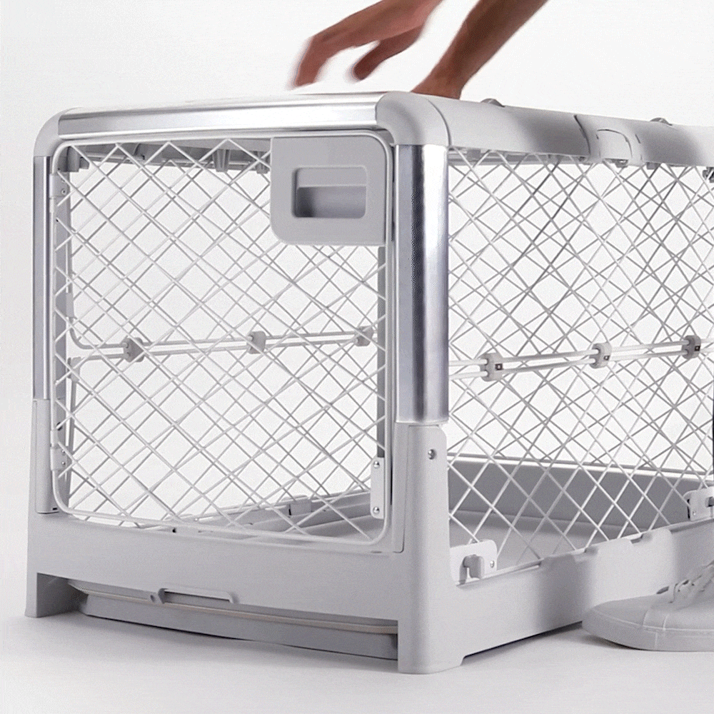 Woman expanding and collapsing Revol Dog Crate with its innovating mechanism